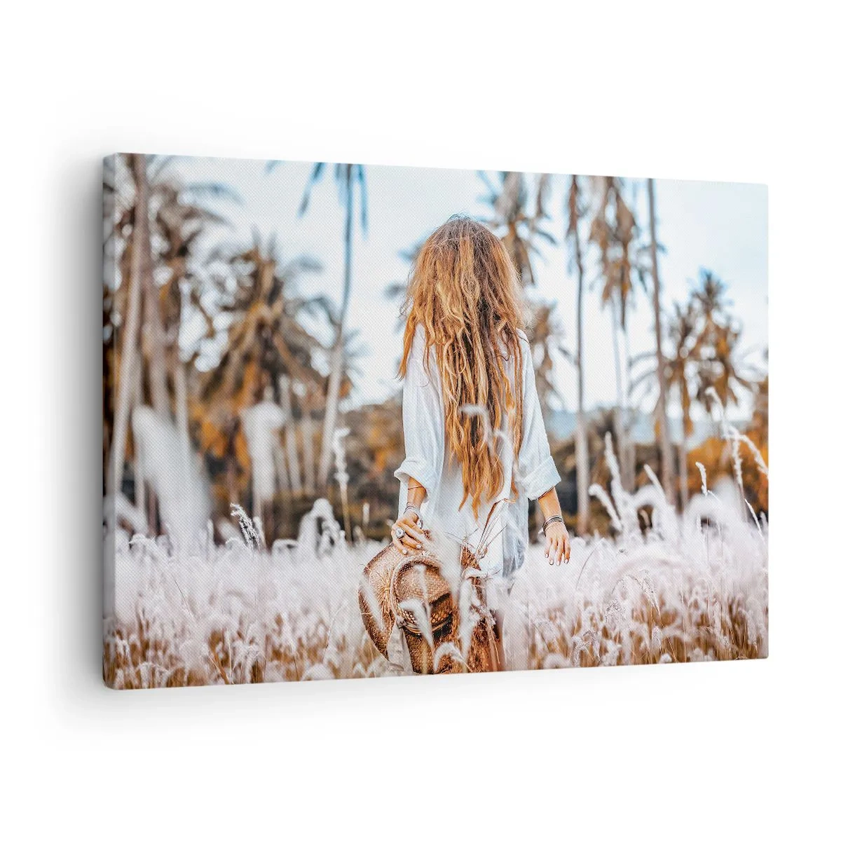 Obraz na płótnie - Kobieta w polu traw z palmami w tle o zachodzie słońca - 70x50cm - Zrodzona z puchu traw - Nowoczesna dekoracja ścienna do salonu i sypialni ARTTOR