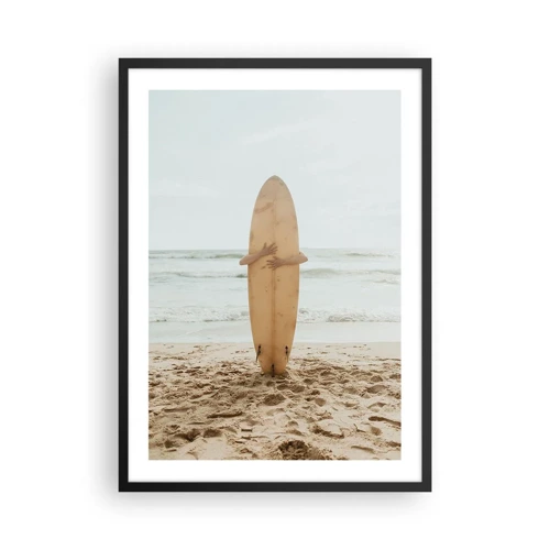 Plakat w czarnej ramie - Z miłości do fal - Osoba trzymająca deskę surfingową na plaży, z widokiem na morze - 50x70cm